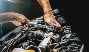 Auto mechanic working on car engine in mechanics garage. Repair service. authentic close-up shot